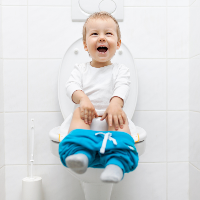 Boy sitting on toilet laughing